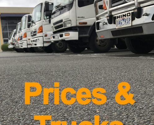 Office movers Melbourne — fleet of Jake Move commercial trucks lined up in a yard showing available truck sizes.
