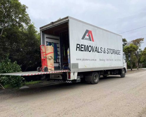 Office movers Melbourne — Jake Removals and Storage truck with rear doors open and boxes loaded, ready for departure.